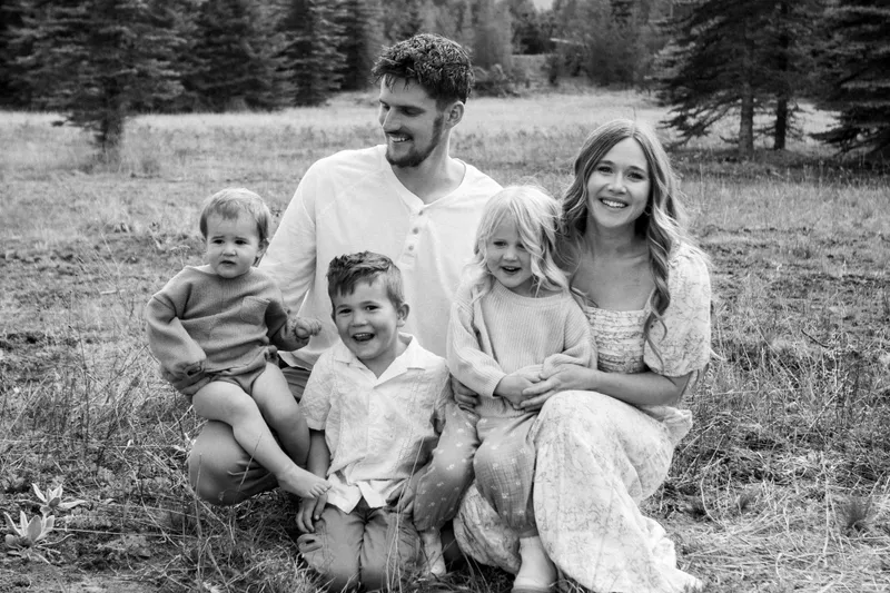 Black and white photo of the Draxlir family sitting together in a meadow